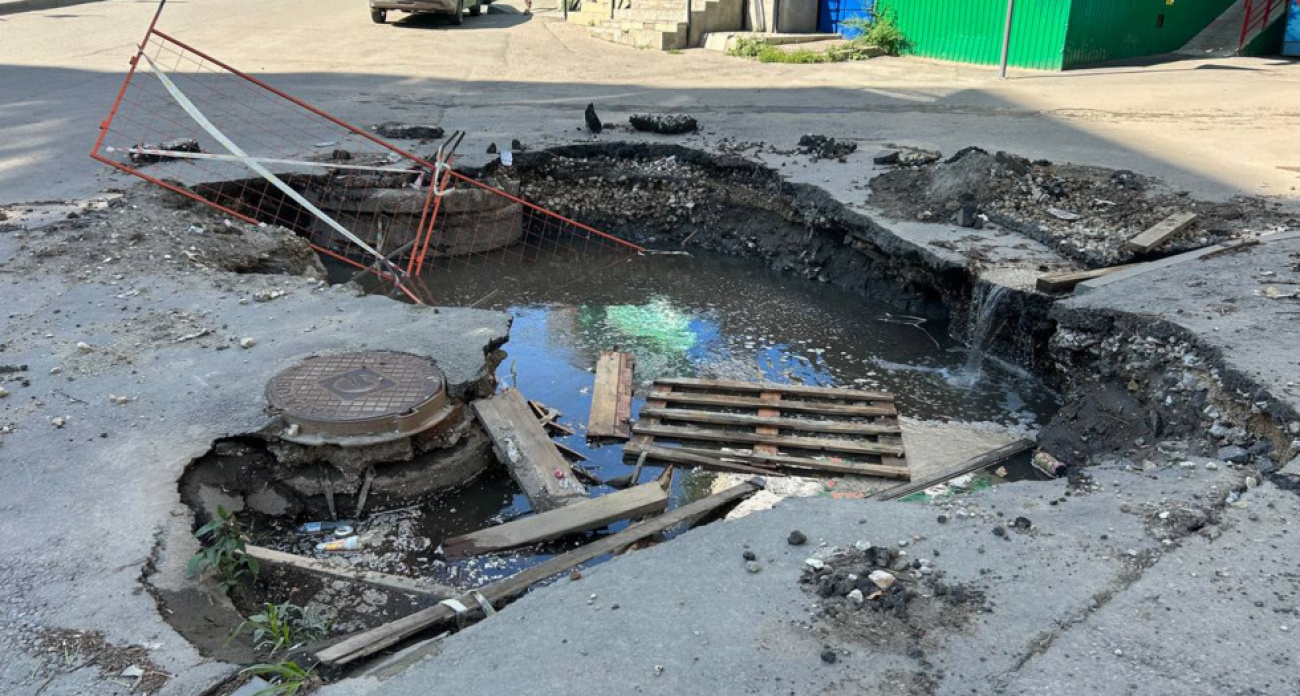 "Портал в ад" на 1-й Дачной: коммунальная яма за полтора месяца поглотила заборчик и угрожает жителям
